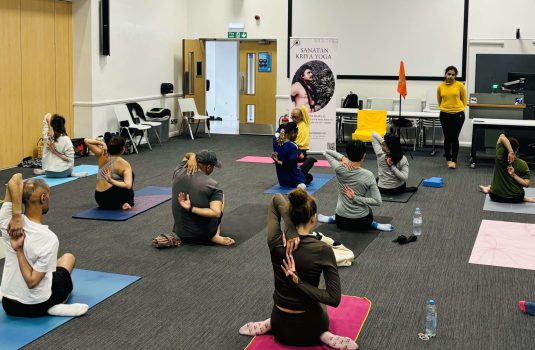 students doing yoga guided by instructor